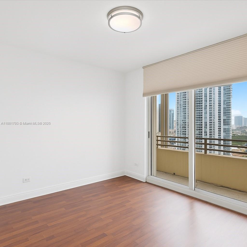 888 Brickell Key Drive, Unit 2510 Miami, FL 33131 - Photo 15 of 22 an empty room with wooden floor and windows