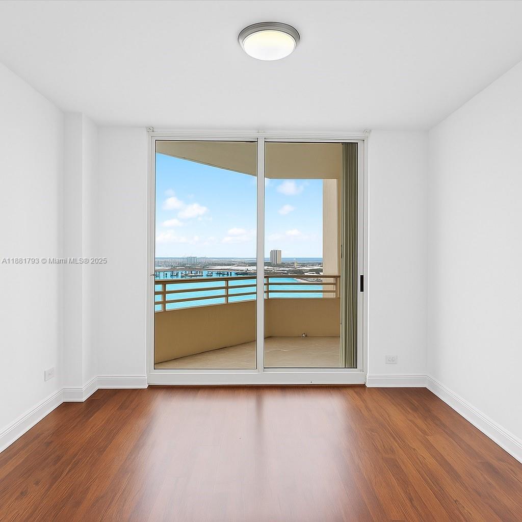 888 Brickell Key Drive, Unit 2510 Miami, FL 33131 - Photo 17 of 22 an empty room with wooden floor and window