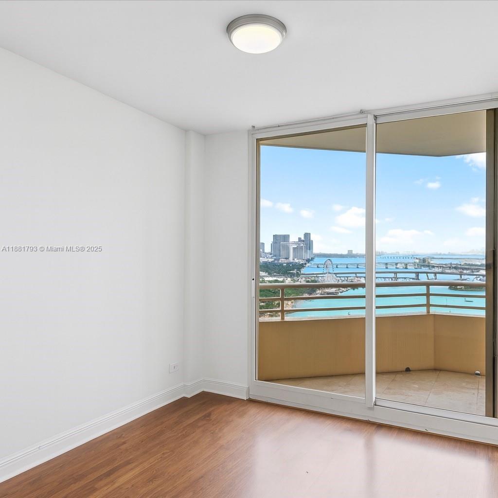 888 Brickell Key Drive, Unit 2510 Miami, FL 33131 - Photo 18 of 22 an empty room with wooden floor and windows