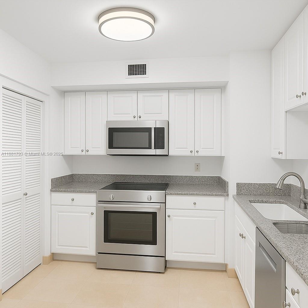 888 Brickell Key Drive, Unit 2510 Miami, FL 33131 - Photo 20 of 22 a kitchen with white cabinets stainless steel appliances and sink