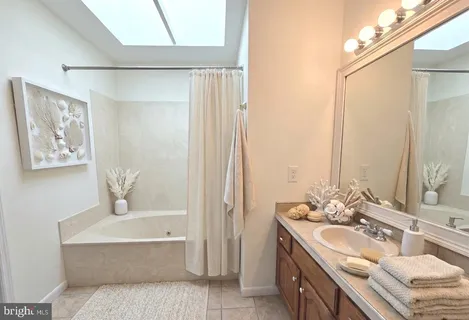 a bathroom with a tub a sink and mirrors