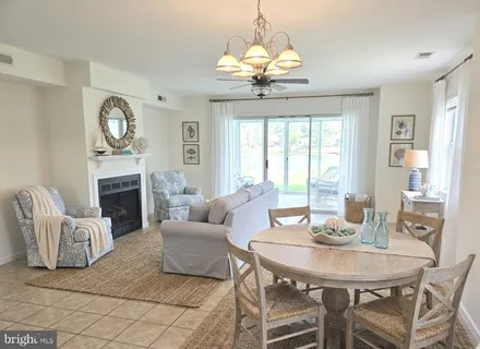 a living room with furniture a fireplace and a chandelier