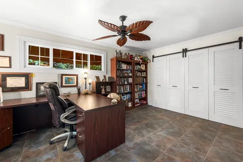 a view of a workspace with furniture and a bookshelf