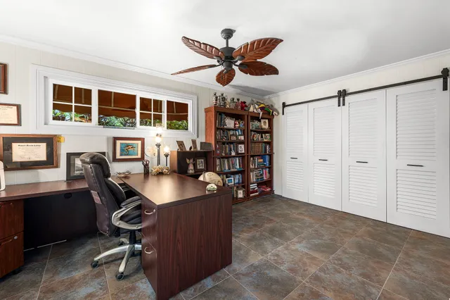 a view of a workspace with furniture and a bookshelf