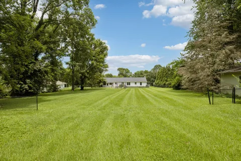 a view of yard with swimming pool and trees