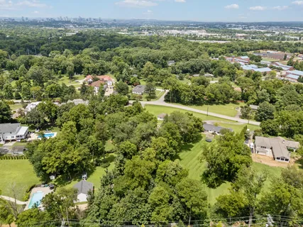 an aerial view of residential house with outdoor space and trees all around