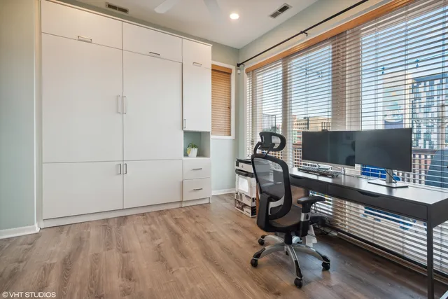 a view of a workspace with furniture and a window