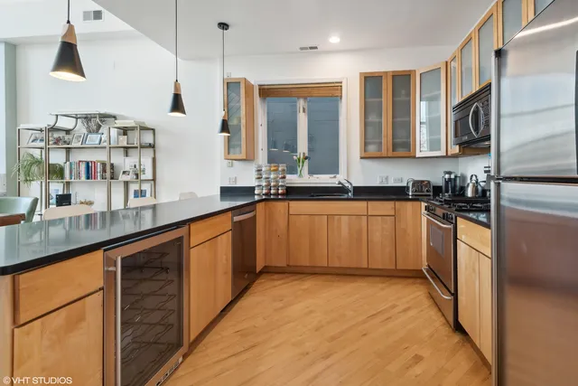 a large kitchen with stainless steel appliances granite countertop a sink counter space cabinets and a large window