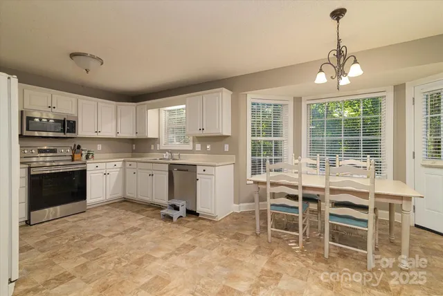 a kitchen with a stove a sink dishwasher a dining table and chairs