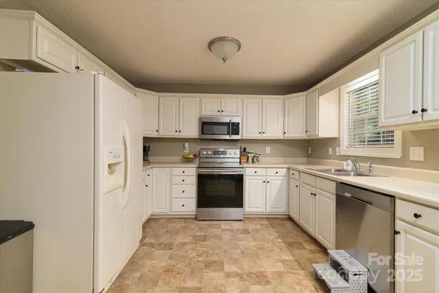 a kitchen with granite countertop white cabinets and white appliances