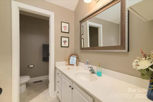 a bathroom with a toilet sink and mirror