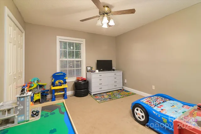 a living room with a baby crib furniture and a window