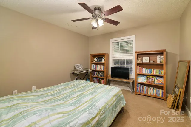 a bedroom with a bed a dresser and a book shelf