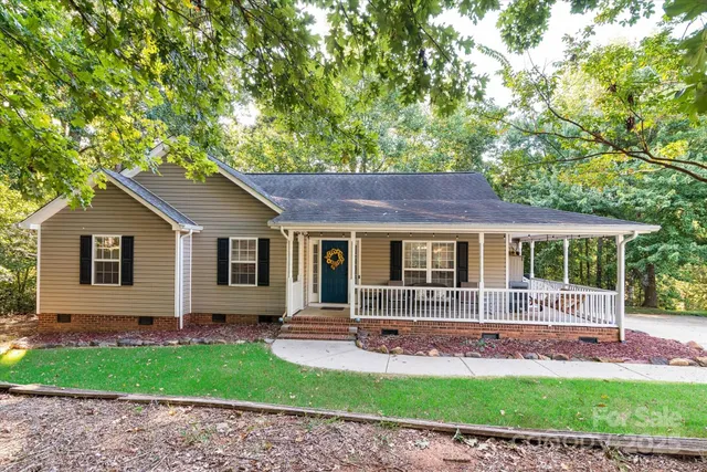 a front view of a house with a garden and yard