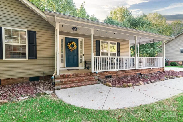 a view of a house with a small yard and wooden fence