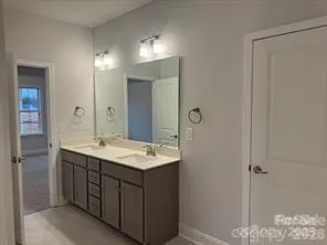 a bathroom with a double vanity sink and mirror