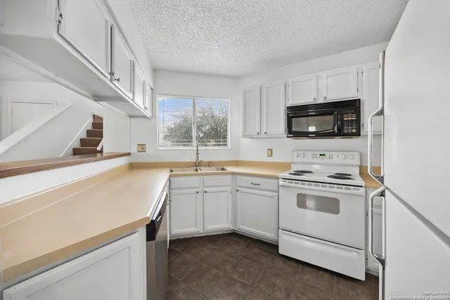 a kitchen with a sink stove top oven and cabinets