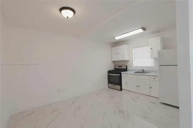 a kitchen with granite countertop white cabinets and white appliances