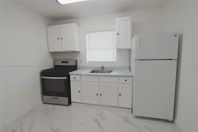 a kitchen with sink cabinets and refrigerator