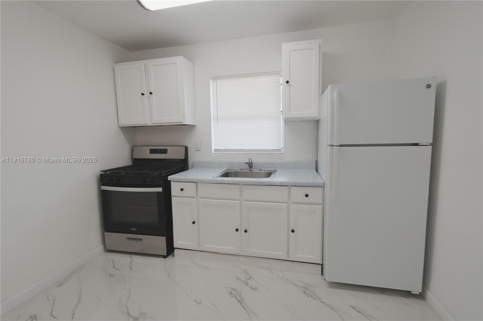 1245 West 24th Street, Unit 210 Hialeah, FL 33010 - Photo 12 of 22 a kitchen with sink cabinets and refrigerator
