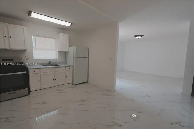 a kitchen with a stove a sink and a refrigerator
