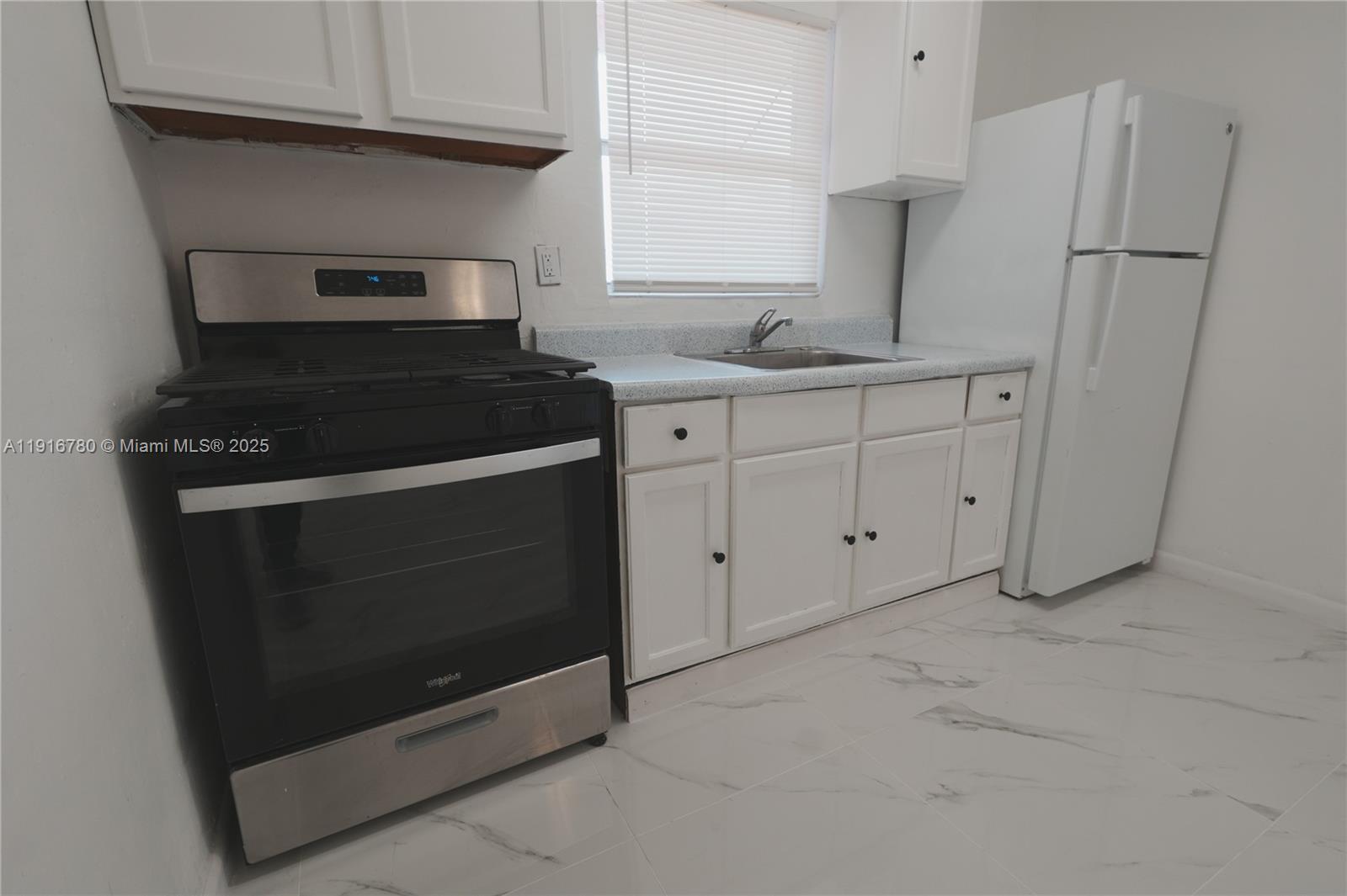 1245 West 24th Street, Unit 210 Hialeah, FL 33010 - Photo 3 of 22 a kitchen with appliances and cabinets