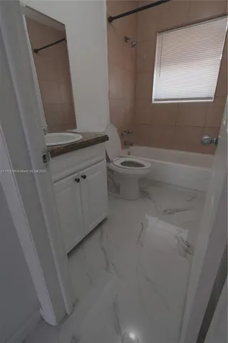 a bathroom with a granite countertop sink a toilet and a mirror