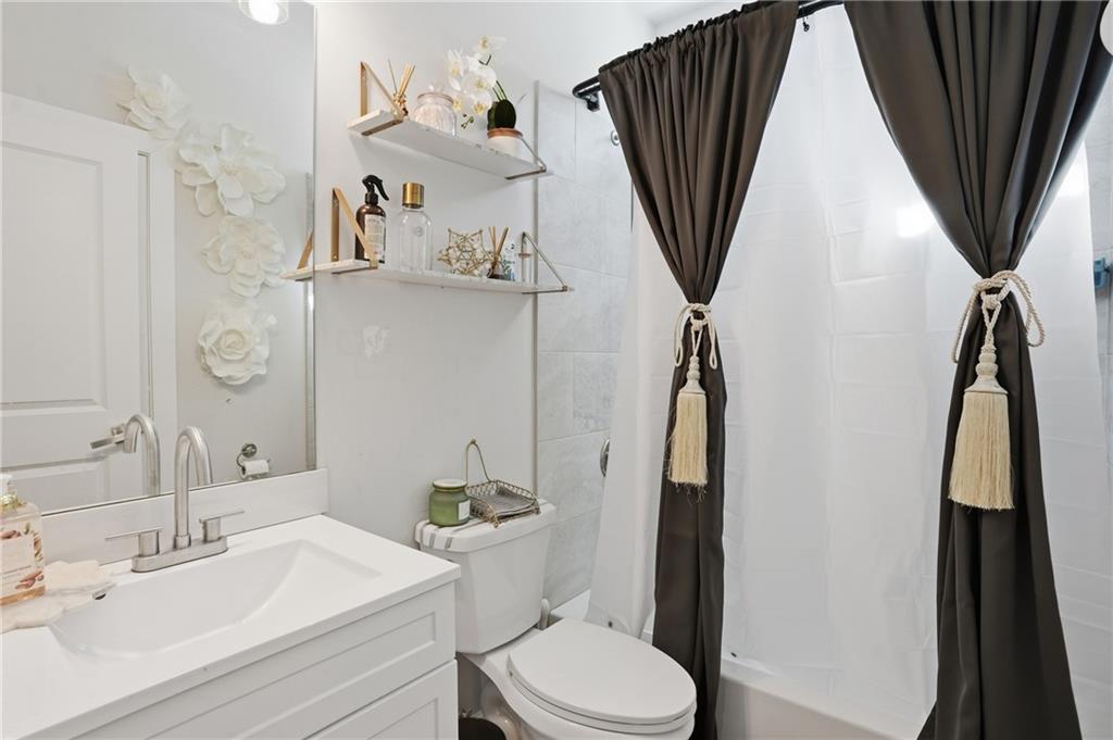 5663 Eternal Drive Atlanta, GA 30349 - Photo 22 of 37 a bathroom with a sink a toilet and vanity