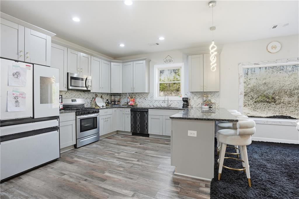 5663 Eternal Drive Atlanta, GA 30349 - Photo 7 of 37 a kitchen with granite countertop white cabinets and white appliances