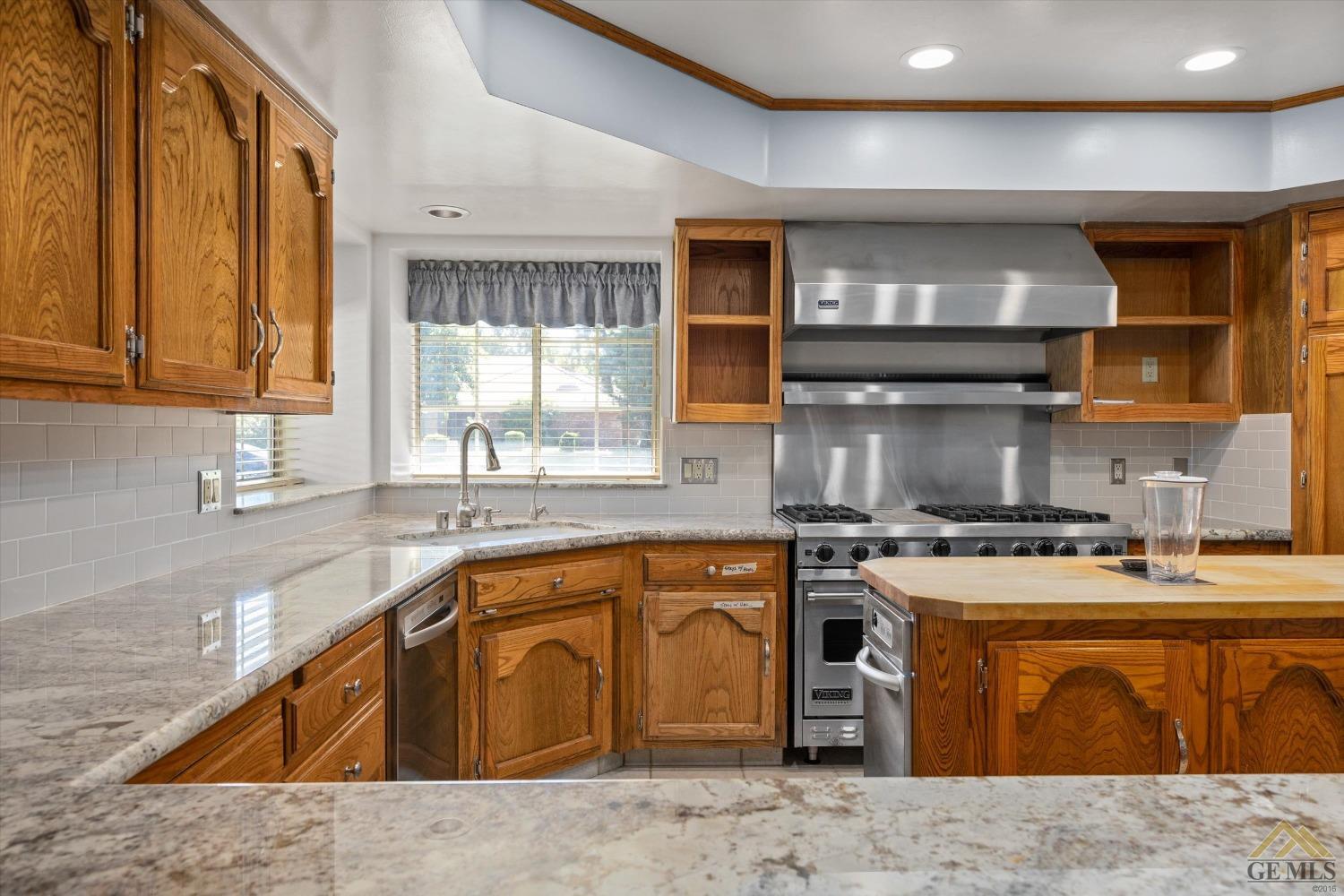 Undisclosed Address Bakersfield, CA 93312 - Photo 25 of 46 a kitchen with stainless steel appliances granite countertop a sink a stove a counter space and cabinets