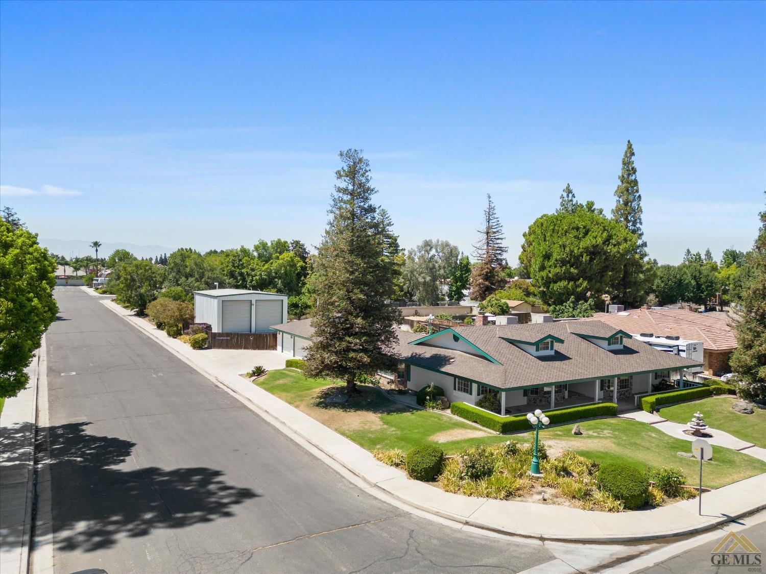 Undisclosed Address Bakersfield, CA 93312 - Photo 3 of 46 a aerial view of a house with swimming pool and large trees
