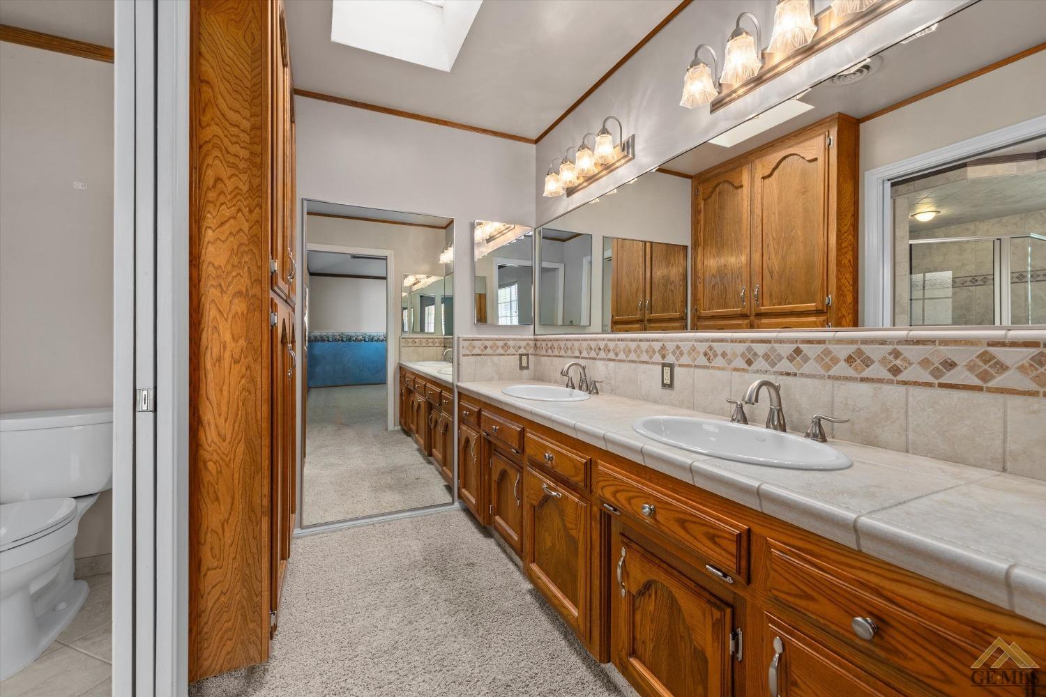 Undisclosed Address Bakersfield, CA 93312 - Photo 33 of 46 a bathroom with a double vanity sink and a mirror