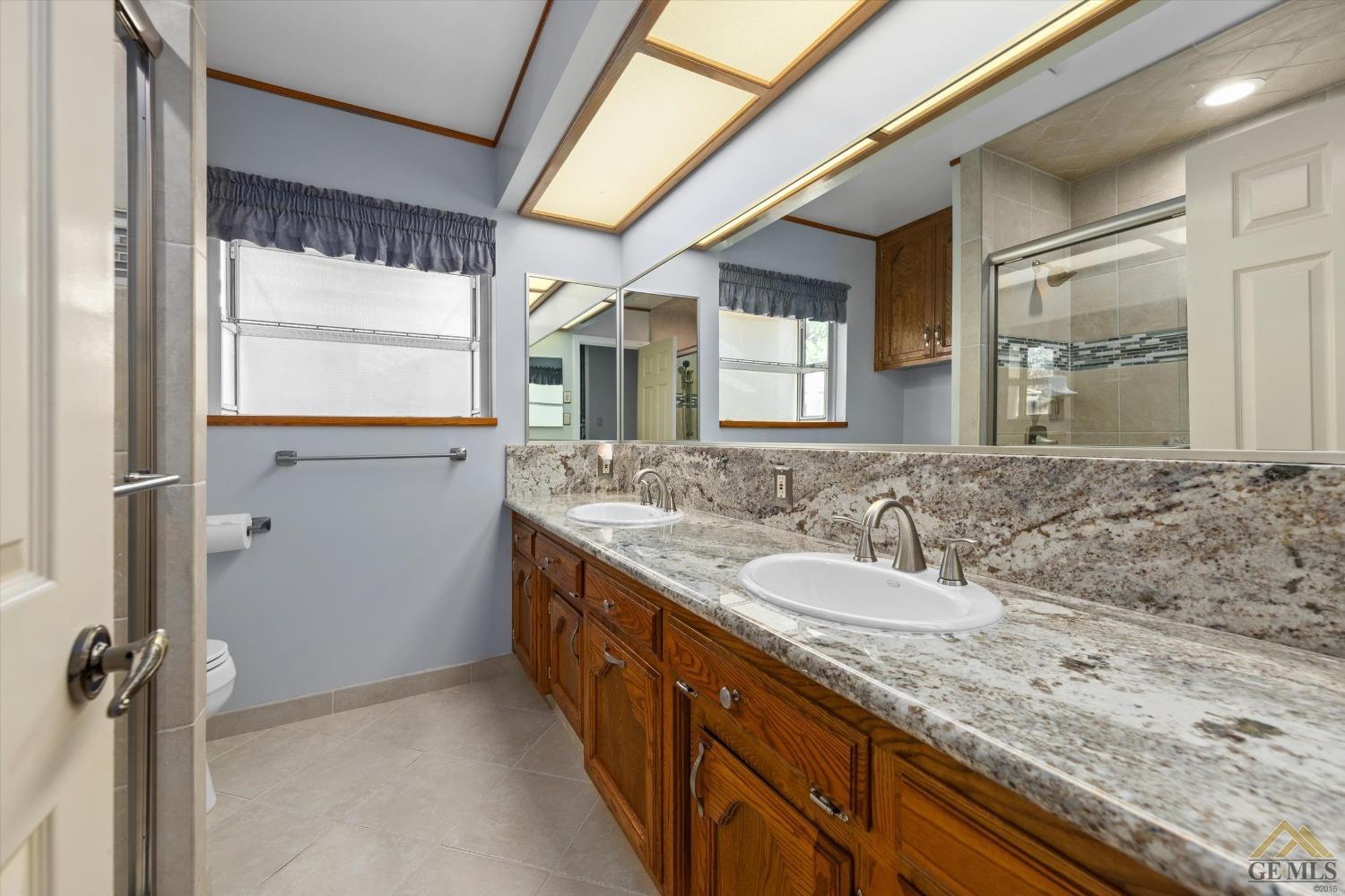 Undisclosed Address Bakersfield, CA 93312 - Photo 40 of 46 a bathroom with a granite countertop sink mirror and double