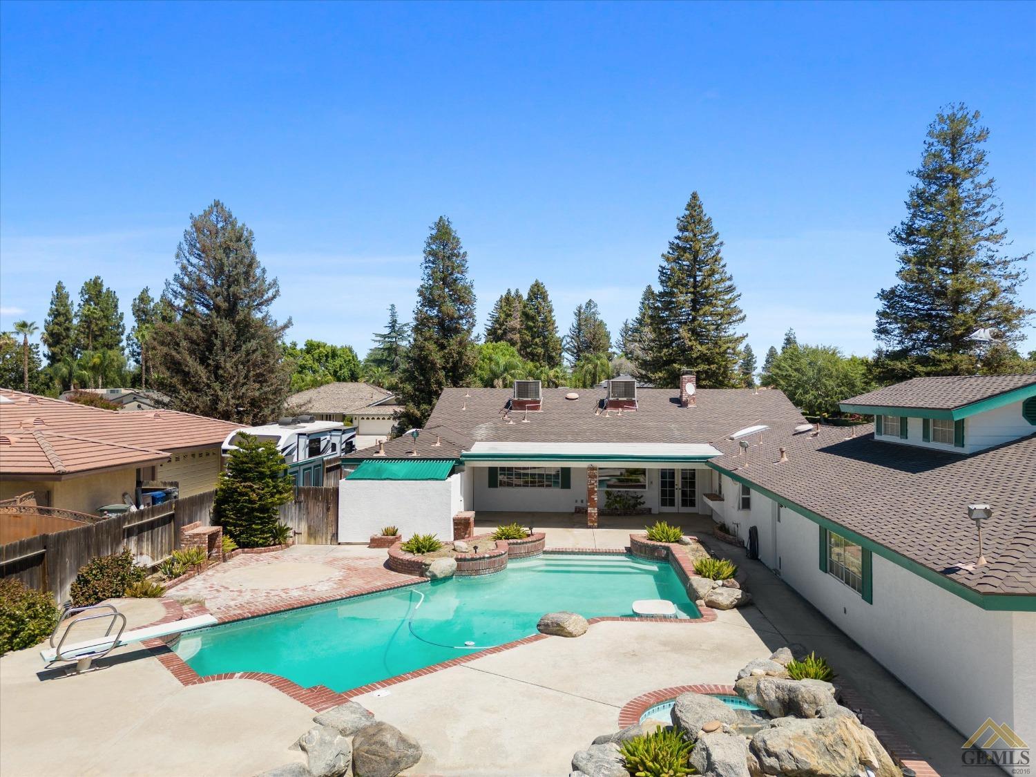 Undisclosed Address Bakersfield, CA 93312 - Photo 5 of 46 a view of a white house with a big yard plants and large tree