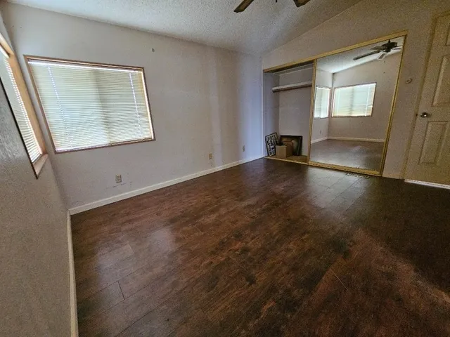 an empty room with wooden floor and windows