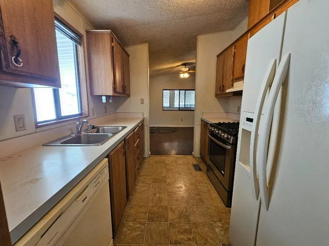 a kitchen with stainless steel appliances granite countertop a stove a sink and a refrigerator