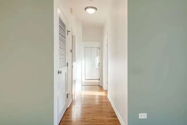 a view of a hallway with wooden floor