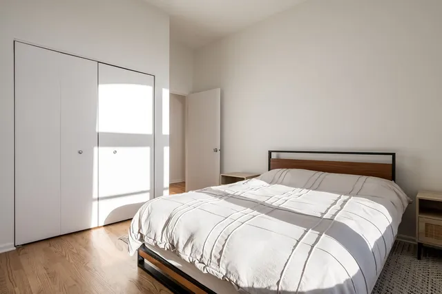 a large bed sitting in a bedroom next to a window