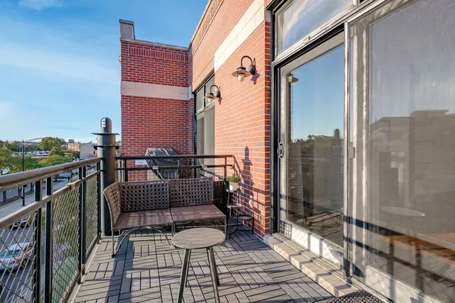 a balcony with wooden floor and outdoor seating