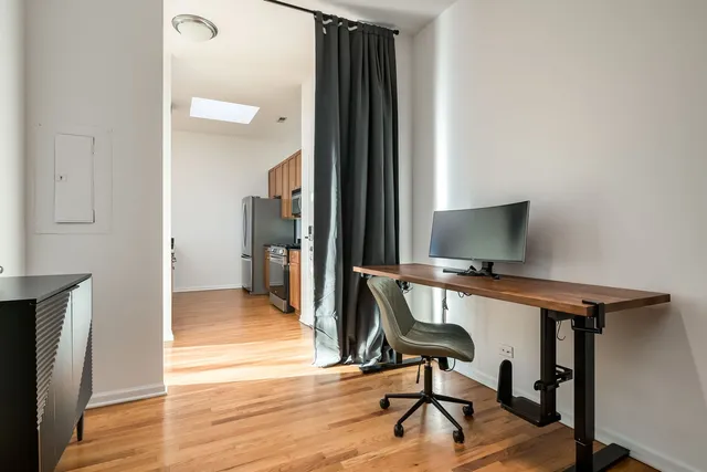 a view of a workspace with furniture and wooden floor