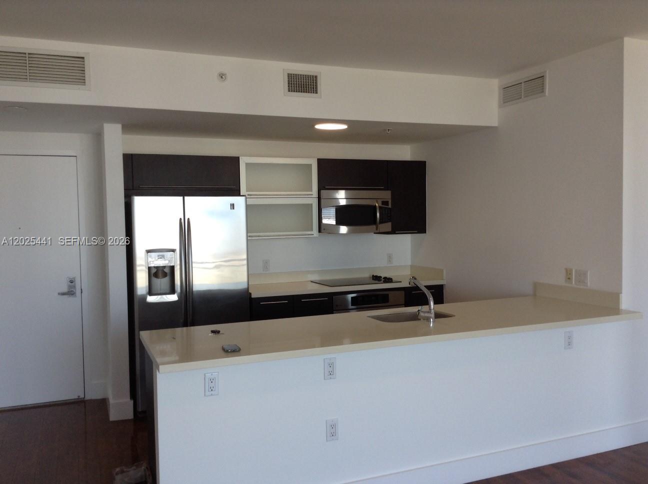 90 Southwest 3rd Street, Unit 3708 Miami, FL 33130 - Photo 5 of 13 a kitchen with a sink and a microwave