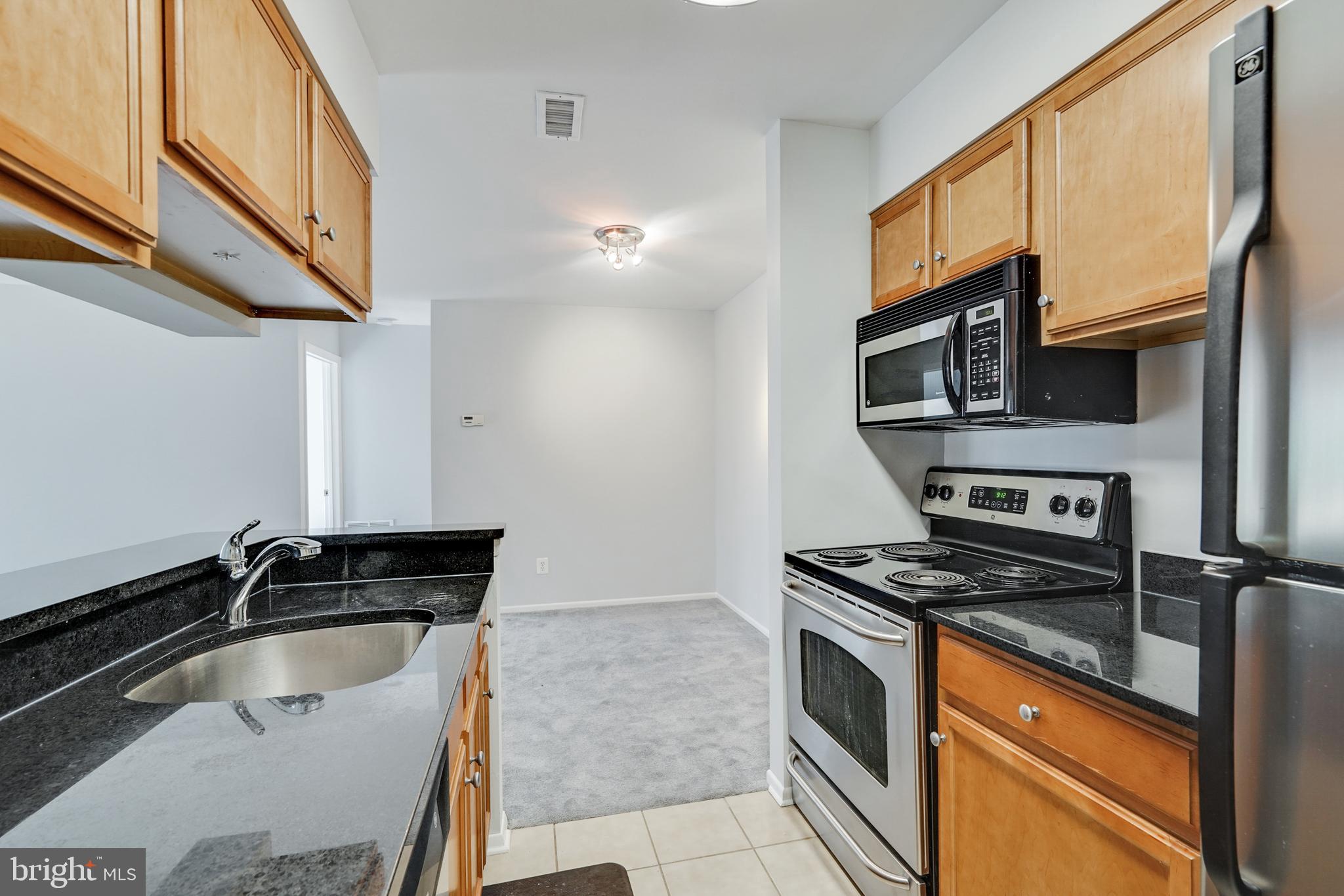 1781 Jonathan Way, Unit 1781I Reston, VA 20190 - Photo 12 of 48 a kitchen with granite countertop a sink and a stove top oven