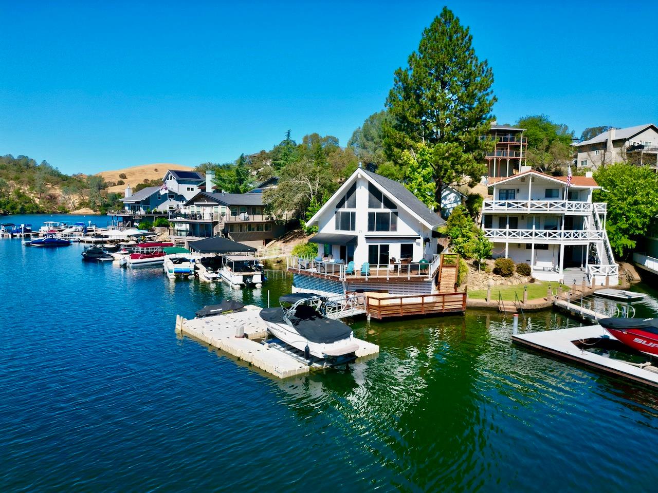 an aerial view of a house with swimming pool garden and lake view