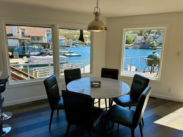 a dining room with furniture a floor to ceiling window and wooden floor
