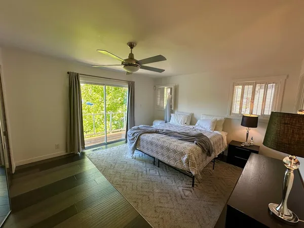 a spacious bedroom with a bed a window and a chandelier