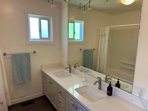a bathroom with double vanity sink and a mirror