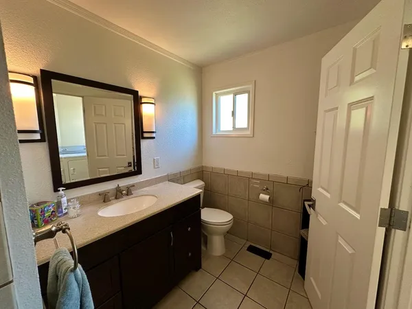 a bathroom with a double vanity sink toilet and mirror