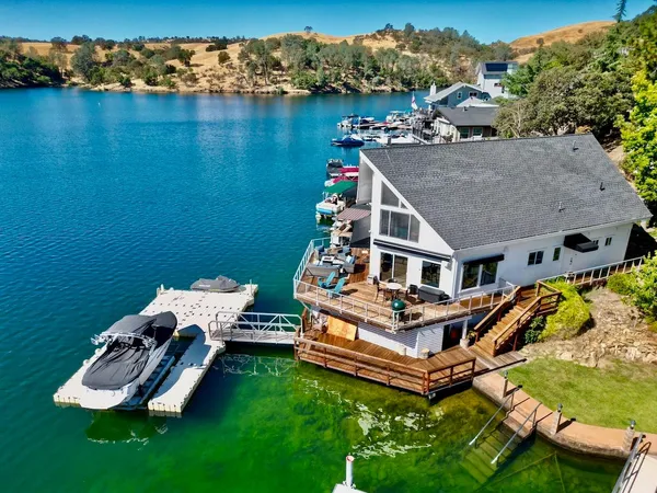 an aerial view of a house with a garden and lake view