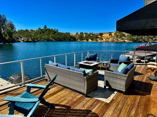 a view of a roof deck with couches wooden floor and a floor to ceiling window