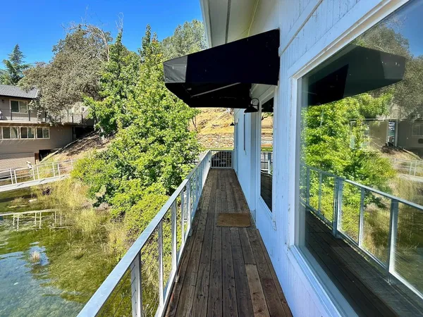 a view of balcony with wooden floor and fence